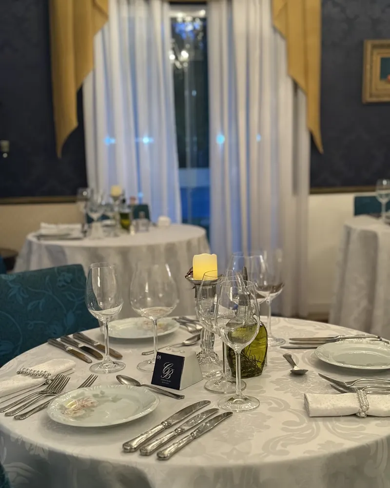 Mesa posta com vela, taças de cristal e o monograma do Cordon Blanc