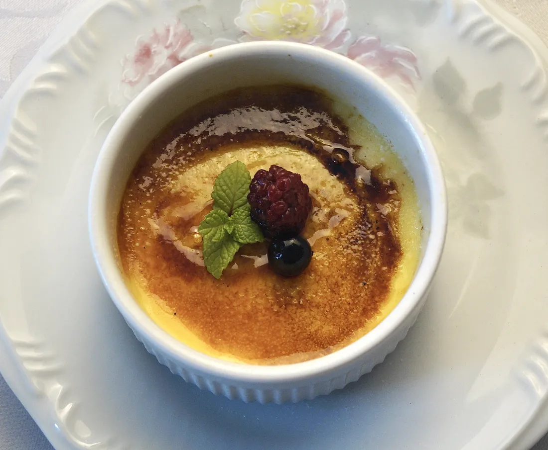 Crème Brûlée com casquinha caramelizada, framboesa, mirtilo e folha de hortelã