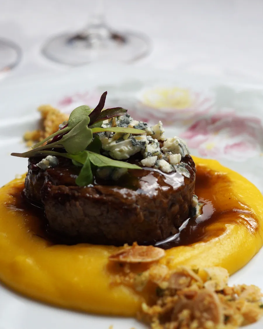 Mignon Angus ao molho de queijo sobre mousseline de batata com cabotiá e crocante de amêndoas
